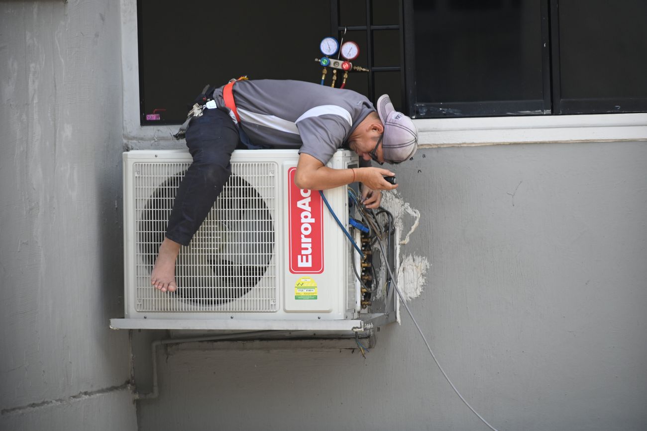 Technician servicing an outdoor air-conditioning unit